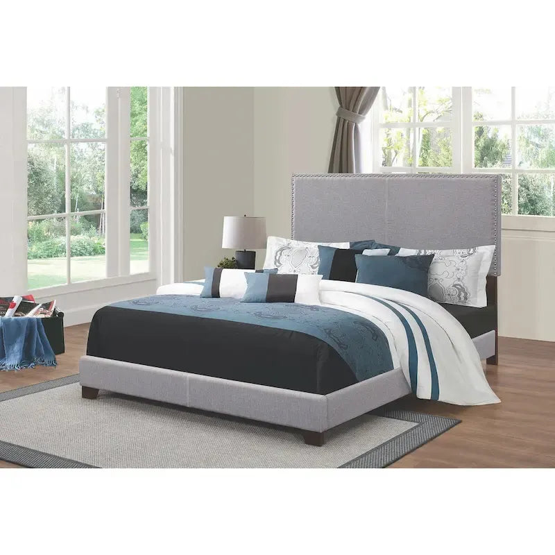 Cama tapizada gris de diseño moderno con adornos de tachuelas